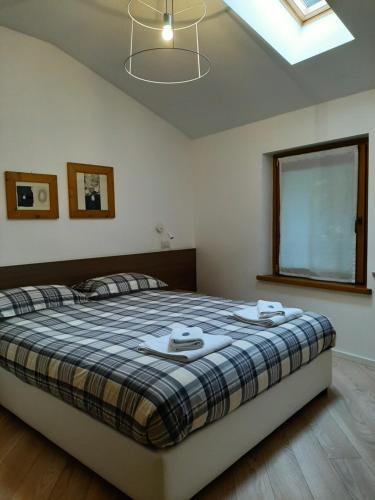 a bedroom with a large bed with a plaid blanket at Osteria Al Ponte in Udine