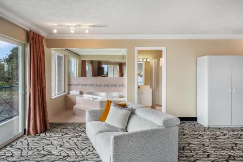 a living room with a couch and a bathroom at Glen Lyon Inn in Port Hardy