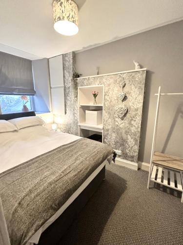 a bedroom with a large bed and a chair at Small Cosy Flat in Helensburgh