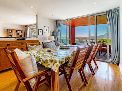 a kitchen and dining room with a table and chairs at 5 Suikerbossie in Gordonʼs Bay