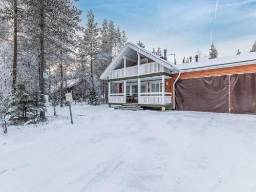 a house in the snow next to a garage at Holiday Home Arha by Interhome in Äkäslompolo