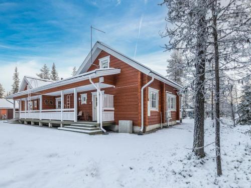 a wooden house with snow on the ground at Holiday Home Arha by Interhome in Äkäslompolo