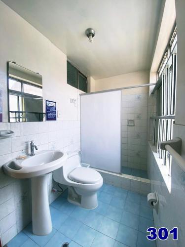 a white bathroom with a sink and a toilet at HOSTAL HOGAR 3 Estrellas - CHEPÉN in Chepén