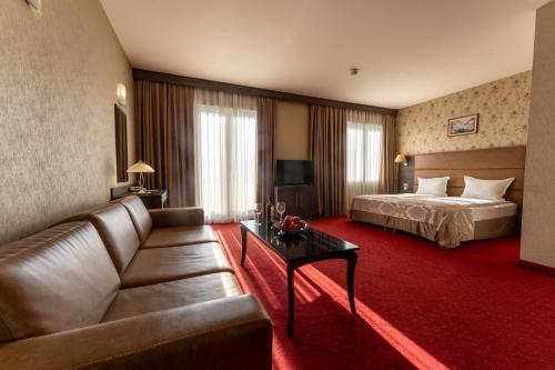 a hotel room with a bed and a couch at Spa Hotel Dvoretsa in Velingrad