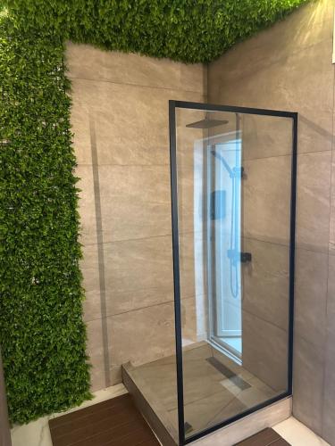 a glass shower in a room next to a wall at Gencian Resort KOPAONIK in Kopaonik