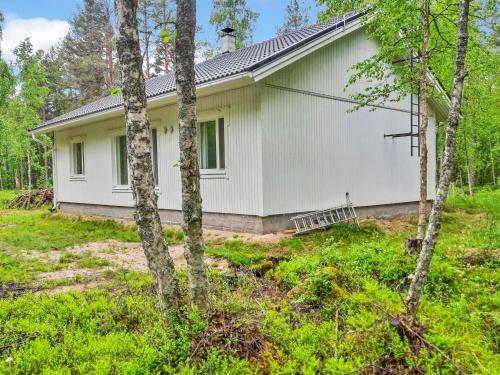 a white house with trees in front of it at Holiday Home Huvikumpu by Interhome in Hailuoto