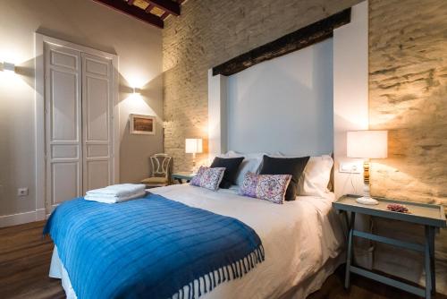 a bedroom with a large bed with a blue blanket at Boutike Apartments in Seville