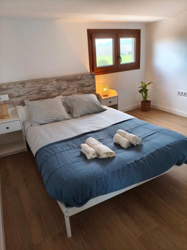 a bedroom with a large bed with two towels on it at La Caseta del Ter in San Juan de Mollet