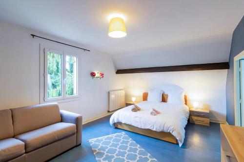 um quarto com uma cama e um sofá em La Gardère em Sarlat-la-Canéda