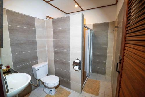 a bathroom with a toilet and a sink and a shower at The Aerie in Pang Mapha