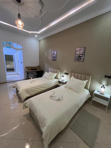 two beds sitting next to each other in a bedroom at Spacious Family Apartment in Er Rachidia