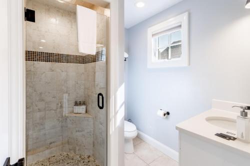 a bathroom with a shower and a toilet and a sink at The Newport Lofts - 410 Thames Street in Newport
