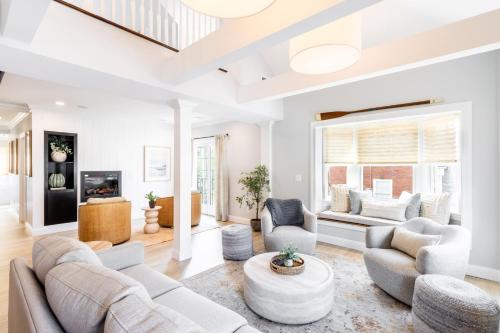 a living room with white furniture and a large window at The Newport Lofts - 410 Thames Street in Newport