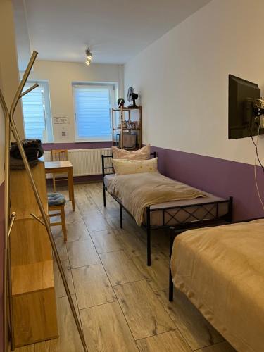 a room with two beds and a flat screen tv at Fremdenzimmer Sas in Hückelhoven