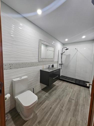 a bathroom with a toilet and a sink and a shower at Villa Barros in Câmara de Lobos