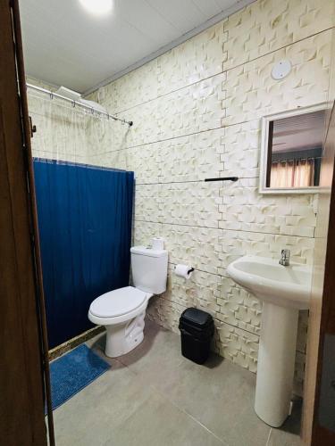 a bathroom with a toilet and a sink at Sol e Sal Suítes Aconchegantes in Saquarema