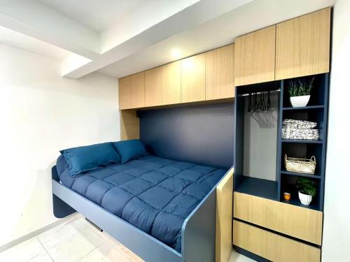 a bedroom with a blue bed in a room at Living Alameda in Querétaro
