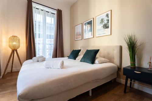 a bedroom with a large white bed with blue pillows at Chambre 3 La Madalena in Nice