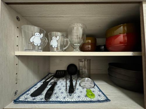 a shelf with some glasses and utensils on it at 東京スカイツリー眺望 一棟貸切 駅徒歩50秒 浅草8分 スカイツリー4分 銀座20分 in Tokyo