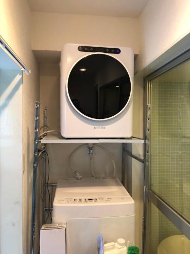a microwave sitting on top of a refrigerator at 東京スカイツリー眺望 一棟貸切 駅徒歩50秒 浅草8分 スカイツリー4分 銀座20分 in Tokyo