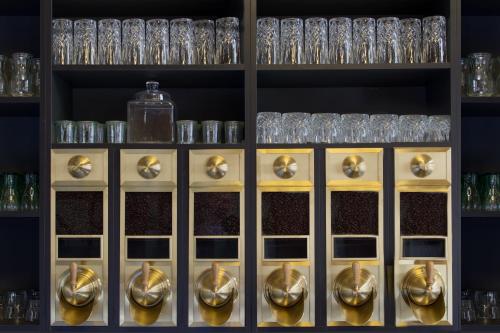 a shelf filled with gold and silver glasses at Hotel Ovo malo duše in Sarajevo