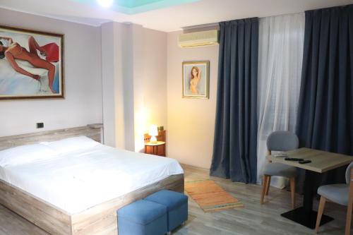ein Schlafzimmer mit einem Bett, einem Tisch und einem Stuhl in der Unterkunft Hotel Sfinks Elbasan Albania in Elbasan