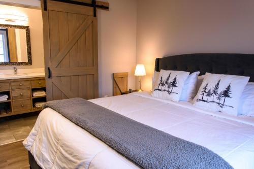 a bedroom with a large bed with a wooden door at Bumblebee Bight Inn in Pilleyʼs Island