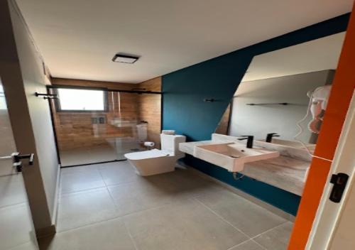 a bathroom with a sink and a toilet and a shower at Minas Garden Hotel in Poços de Caldas