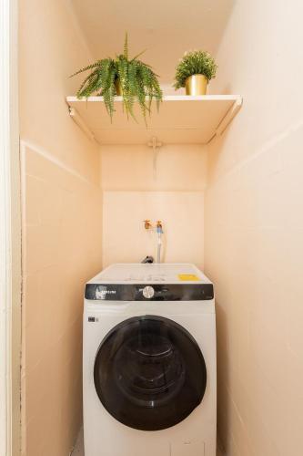 eine Waschmaschine in einem kleinen Raum mit einem Regal in der Unterkunft Casa céntrica con 4 habitaciones y estacionamiento in Puebla