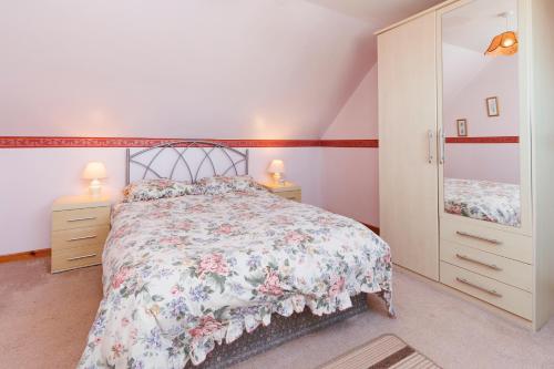a bedroom with a large bed and two night stands at Cosy Croft in Lower Shader