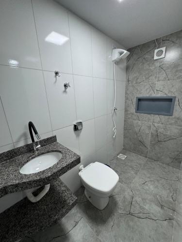 a bathroom with a toilet and a sink at Mini FLAT 01 em Jataí Go in Jataí