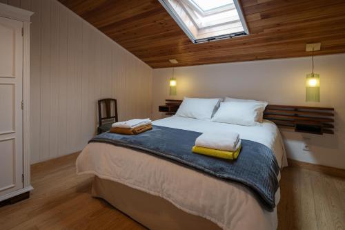 a bedroom with a large bed with two towels on it at Quinta de São Caetano - São Miguel Açores in Populo