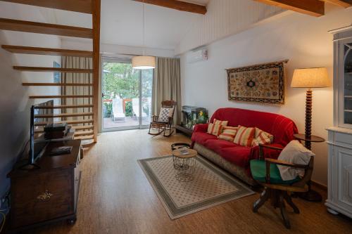 a living room with a red couch and a table at Quinta de São Caetano - São Miguel Açores in Populo
