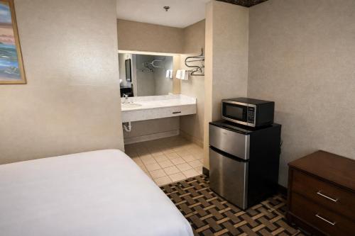 a hotel room with a bed and a microwave at Spring Place Inn & Suites in Millington