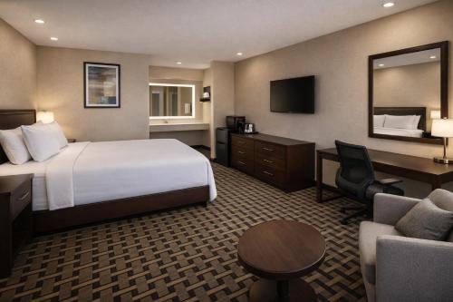 a hotel room with a bed and a desk and chair at Spring Place Inn & Suites in Millington