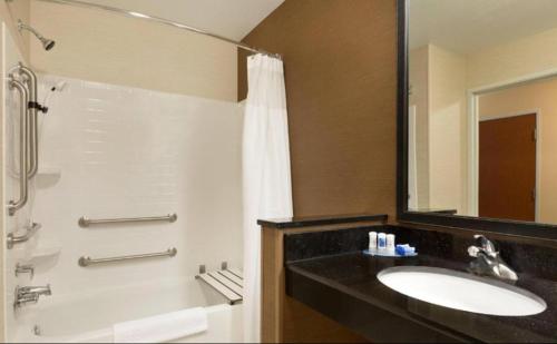 a bathroom with a sink and a shower with a mirror at Country Inn & Suites by Radisson, Bismarck-Mandan in Bismarck
