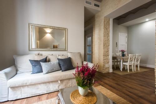 a living room with a white couch and a table at Boutike Apartments in Seville