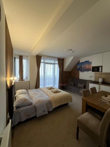 a bedroom with a bed and a living room at Gencian Resort KOPAONIK in Kopaonik