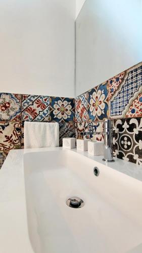 a bathroom with a white sink and colorful tiles at Luxury House in Cefalù