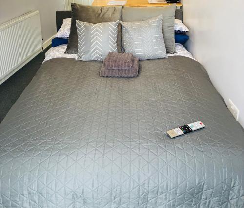 a gray bed with a remote control on it at Your Harrogate Stay in Harrogate