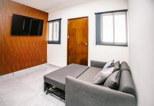 a living room with a couch and a flat screen tv at Departamento a 1 cuadra de 3er anillo in Aguascalientes