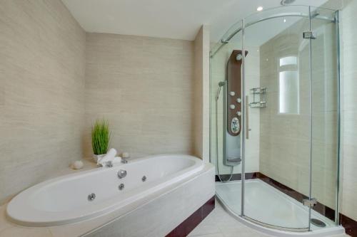 a bathroom with a tub and a glass shower at 4 Bed in Ovingdean oc-bbvale in Rottingdean