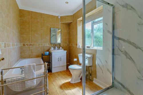 a bathroom with a tub and a toilet and a sink at 3 Bed in Mumbles oc-b27725 in The Mumbles
