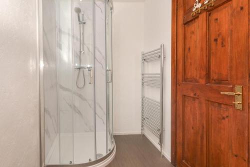 a glass shower in a room with a wooden door at 2 Bed in Padstow oc-w3658 in Saint Merryn