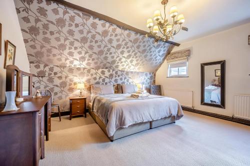 a bedroom with a large bed and a wall at 4 Bed in Alcester oc-s30997 in Alcester