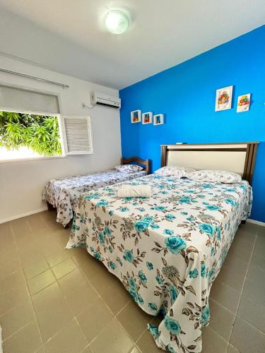 a bedroom with two beds and a blue wall at CASA in Piranhas
