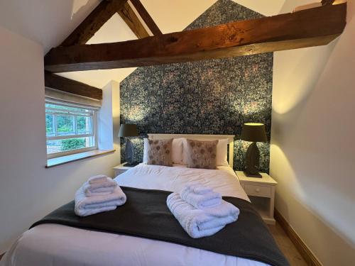 a bedroom with a bed with two towels on it at The Menagerie in Towcester