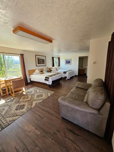 a living room with a bed and a couch in a room at The Riverside Ranch Motel and RV Park Southern Utah in Hatch