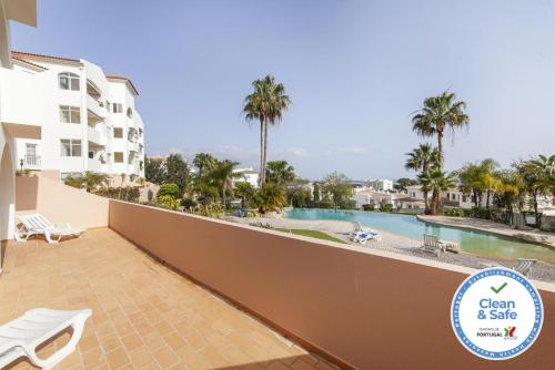 a balcony with a view of a pool and palm trees at A49 - Anastasia Apartment in Lagos in Lagos