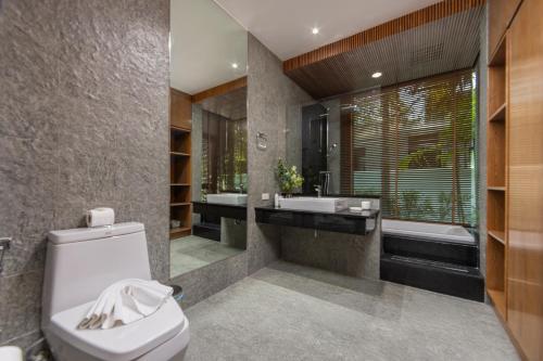 a bathroom with a toilet and a sink and a tub at VILLA PULAU 3 bedroom Baan Bua Estate in Nai Harn Beach